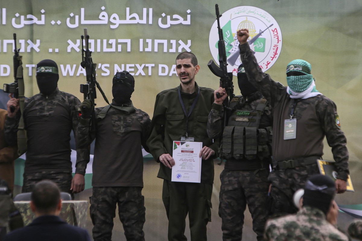 Israeli captive Or Levy, center, who has been held hostage by Hamas in Gaza since Oct. 7, 2023, is escorted by Hamas fighters before being handed over to the Red Cross in Deir al-Balah, central Gaza S ...
