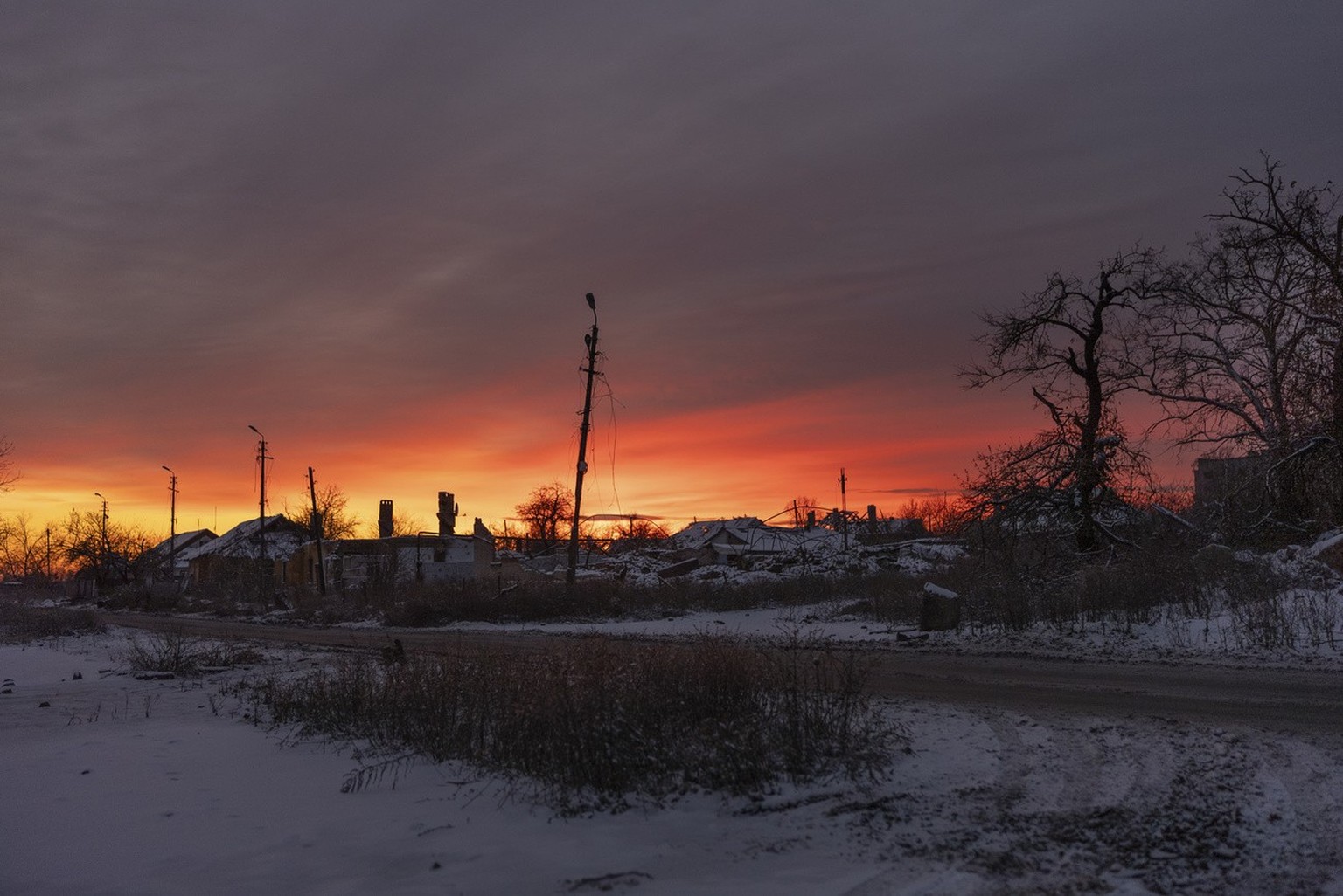 The sun rises over damaged buildings in Chasiv Yar, Donetsk region, Ukraine, Wednesday, Nov. 22, 2023. (AP Photo/Alex Babenko)