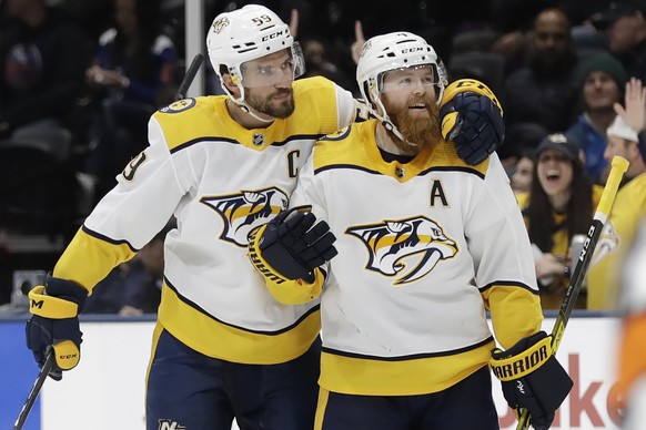 Nashville Predators' Roman Josi, left, celebrates with Ryan Ellis after scoring a goal during the third period of an NHL hockey game against the New York Islanders Tuesday, Dec. 17, 2019, in Unio ...