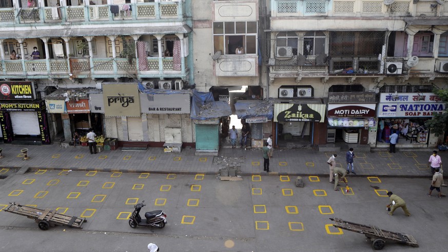 Civic workers mark positions for maintaining physical distance at market place in Mumbai, India, Friday, March 27, 2020. Some of India&#039;s legions of poor and others suddenly thrown out of work by  ...