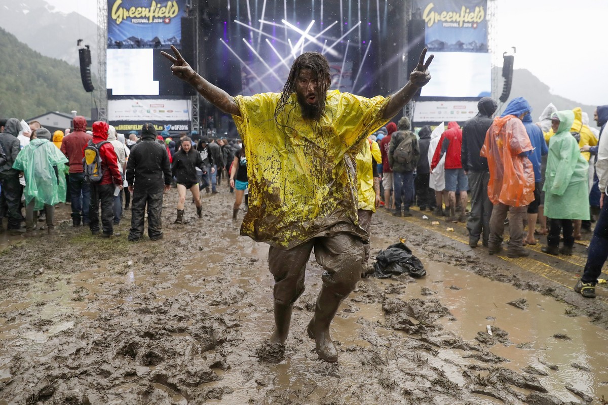 epa05352062 A rock fan enjoys the bad weather at the Greenfield Openair, in Interlaken, Switzerland, 08 June 2016. The openair music event runs from 08 to 11 June. EPA/PETER KLAUNZER