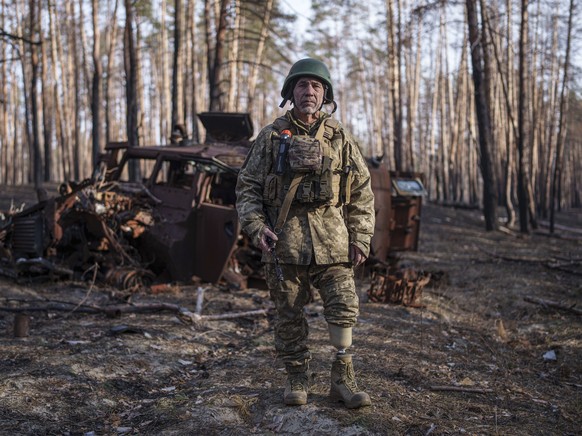 Andrii Serhieiev, a Ukrainian soldier with the 53rd brigade who lost a leg in battle, stands in front of a destroyed Russian armoured vehicle near the frontline in the Lyman direction, Donetsk region, ...