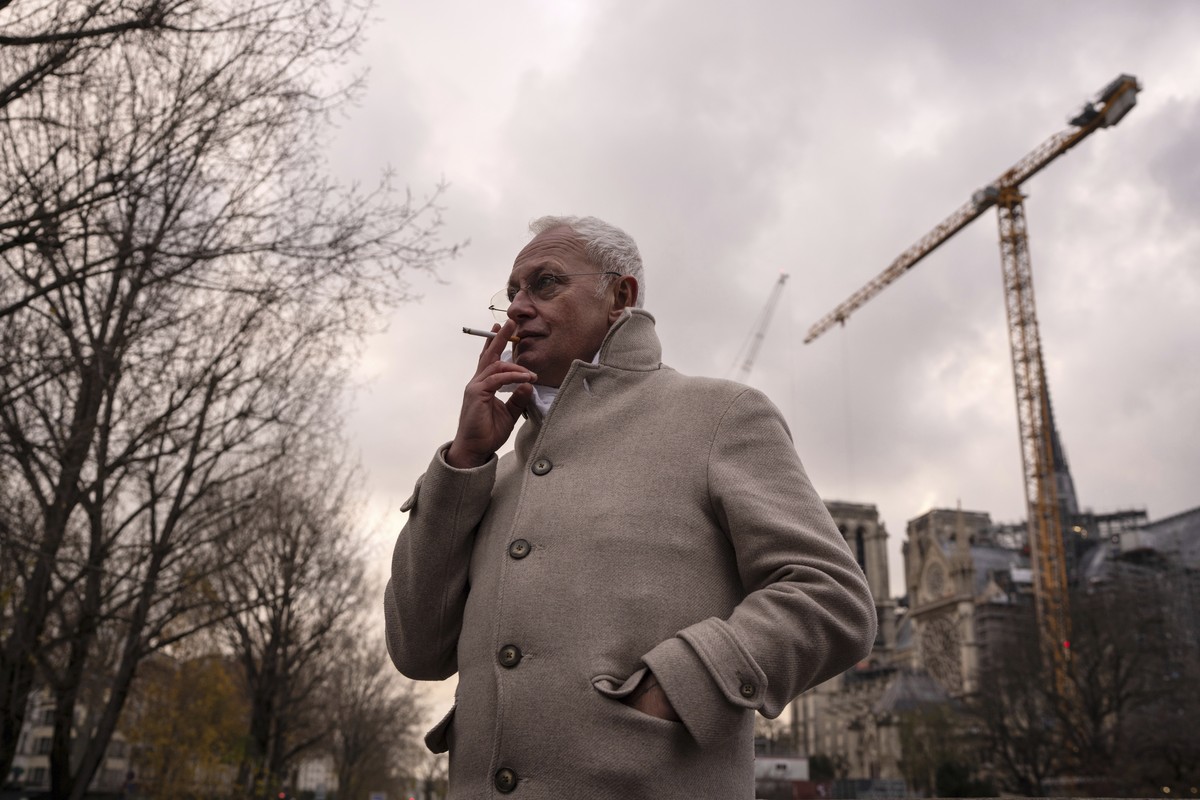 Notre-Dame de Paris cathedral chief architect Philippe Villeneuve smokes a cigarette by the cathedral during an interview with Associated Press, Tuesday, Dec. 3, 2024 in Paris. (AP Photo/Louise Delmot ...