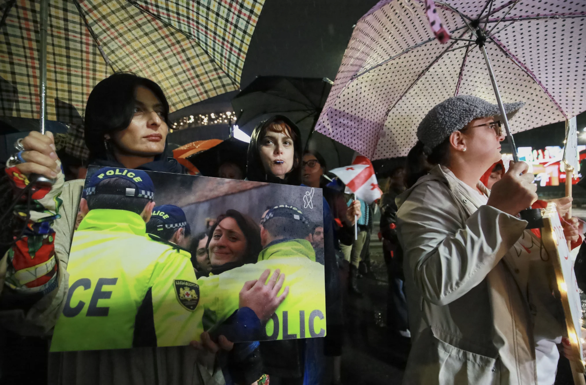 Les manifestants tiennent une photo d'Helen Khoshtaria, chef du parti d'opposition DROA.