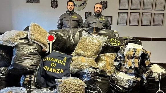 Zwei italienische Polizisten präsentieren den sichergestellten Drogenberg.
