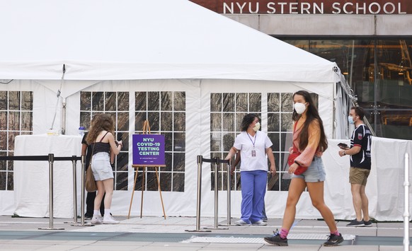 epa08617164 Medical personnel direct students arriving to a COVID-19 testing tent set up at New York University in New York, New York, USA, on 21 August 2020. All students returning to the school are  ...