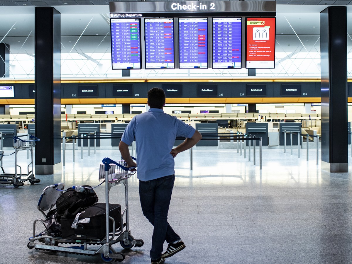 A passenger is looking at the departures board at the Zurich Airport in Zuerich, Switzerland, Tuesday, March 10, 2020. The spreading of the Coronavirus has effects on the passenger volume at Switzerla ...
