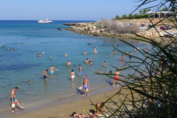 epa06950482 Tourists and locals enjoy the sea during a warm day at Sirina Bay in the southeastern coastal resort of Protaras, Cyprus, 15 August 2018. The Meteorological Services announced that Cyprus  ...