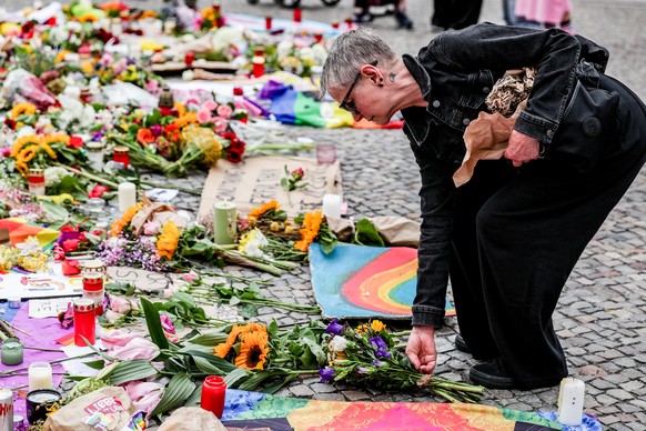 epa13135316 A person leaves flowers at a mourning site in front of the Brandenburg Gate, near the scene where a vehicle plowed into a crowd on the sideline of the Christopher Street Day (CSD) parade i ...