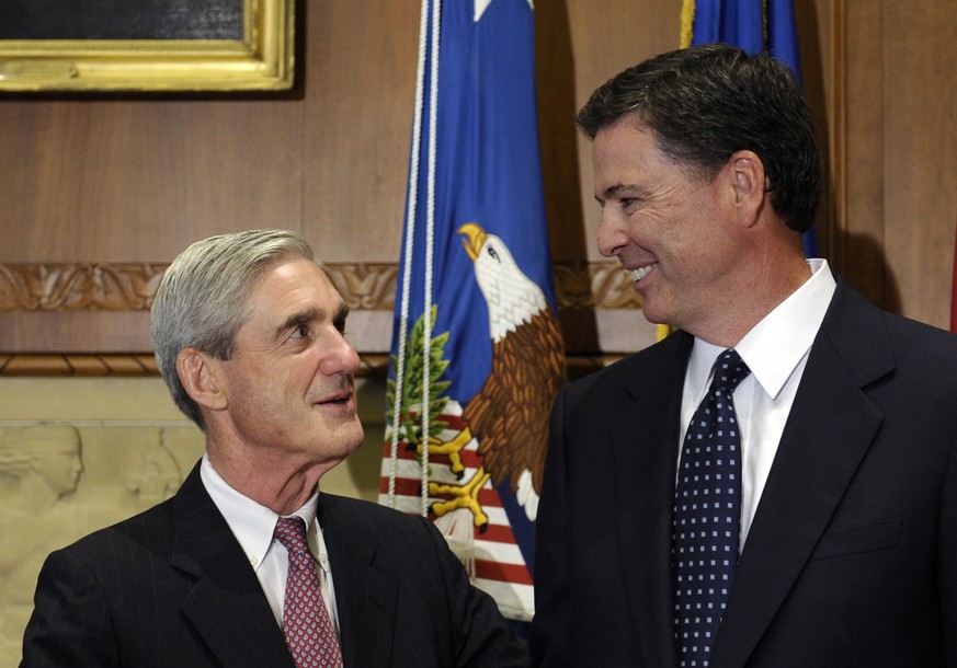 FILE - In this Sept. 4, 2013, file photo, then-incoming FBI Director James Comey talks with outgoing FBI Director Robert Mueller before Comey was officially sworn in at the Justice Department in Washi ...