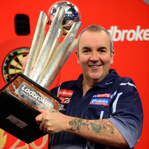 Britain&#039;s Phil Taylor lifts the trophy after winning the PDC World Darts Championship final against Michael van Gerwen of the Netherlands in London, Tuesday Jan. 1, 2013. (AP Photo/PA) UNITED KIN ...