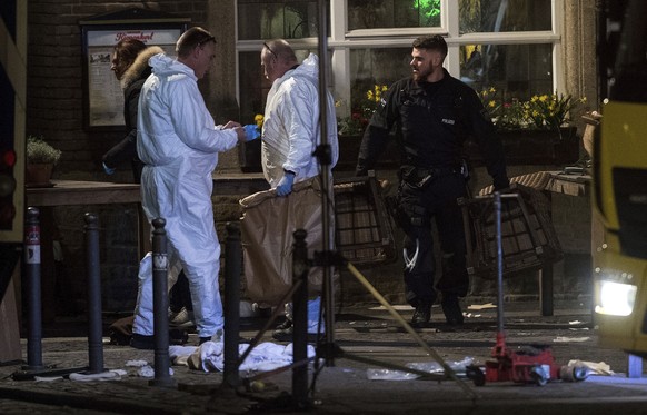 Forensic experts work on the scene in Muenster, western Germany, Sunday, April 8, 2018 where a van crashed into people drinking outside a popular bar von on Saturday afternin the German city of Muenst ...