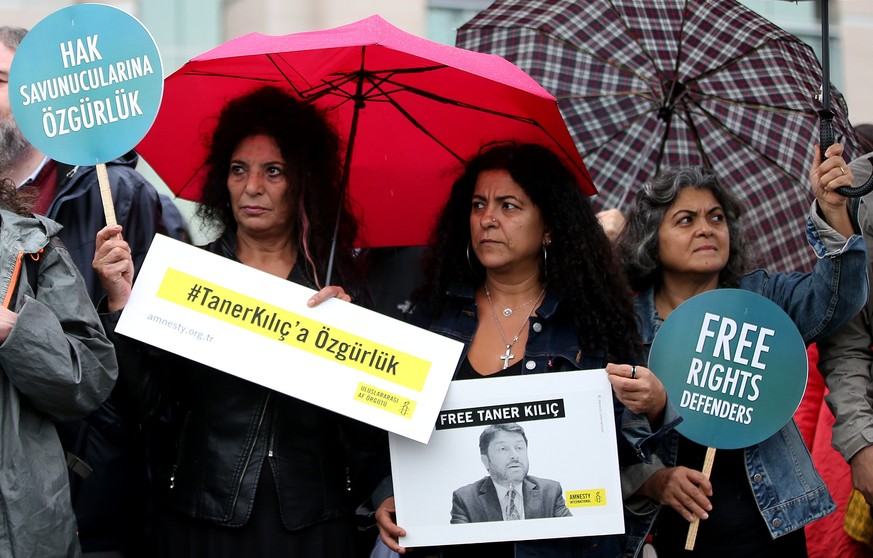 epa06287717 Human right activists hold placards and a picture of one of the arrested human right activists, in front of the Istanbul Courthouse before a trial of arrested eleven human right activists, ...