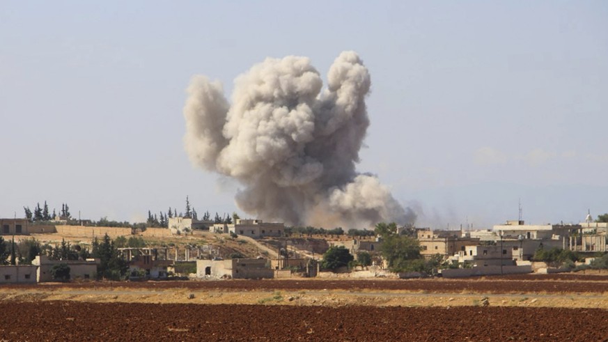 This photo released on Monday, Sept. 10, 2018 by the Syrian Civil Defense group known as the White Helmets, shows smoke rising from a Syrian government airstrike, in Hobeit village, near Idlib, Syria. ...