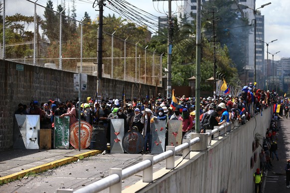 epa10026827 Demonstrators stand in front of riot police, on the streets of Quito, Ecuador, 21 June 2022. The center of Quito was the scene of new disturbances due to clashes between protesters and pol ...