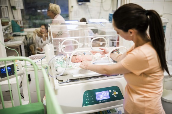 epa08001430 A mother tends to her prematurely born infant lying in an incubator in the Preterm Birth Ward of Heim Pal Children's Hospital in Budapest, Hungary, 15 November 2019 (issued 16 November 201 ...