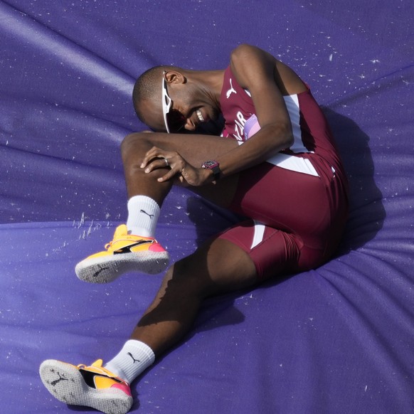 Mutaz Essa Barshim, of Qatar, grabs his calf after clearing the bar during the men&#039;s high jump qualification at the 2024 Summer Olympics, Wednesday, Aug. 7, 2024, in Saint-Denis, France. (AP Phot ...