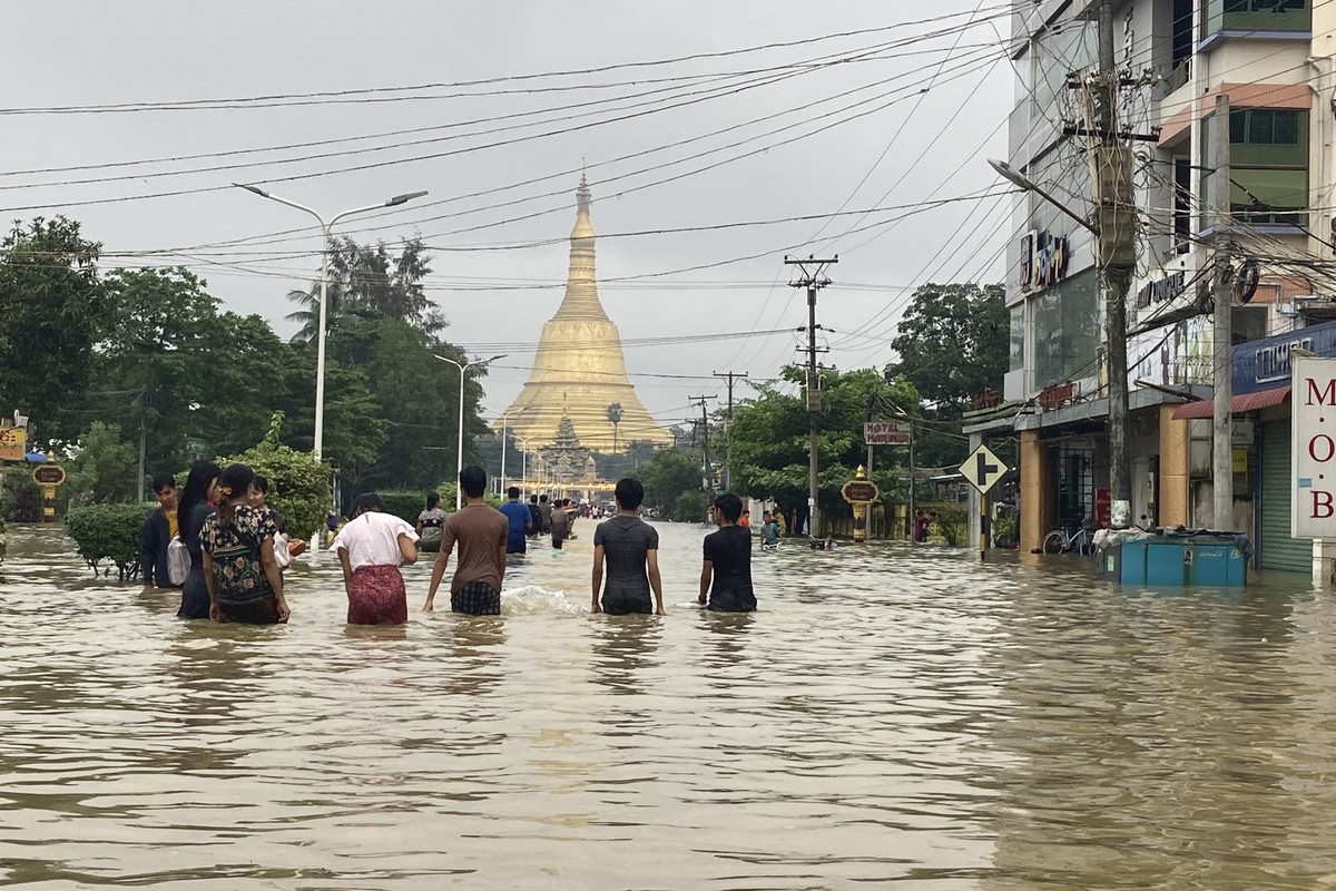 Local residents wade through a flooded road near Shwe Maw Taw pagoda in Bago, about 80 kilometers (50 miles) northeast of Yangon, Myanmar, Monday, Oct. 9, 2023. Flooding triggered by heavy monsoon rai ...