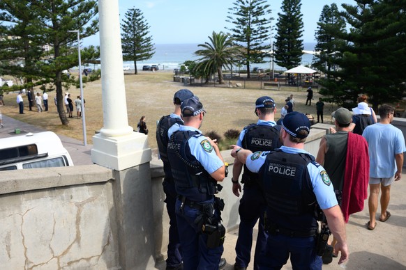 epa12599990 Police look out from the footbridge as Archer Park and the footbridge reopen to the public at Bondi Beach in Sydney, Australia, 18 December 2025. Australia is in mourning following an atta ...