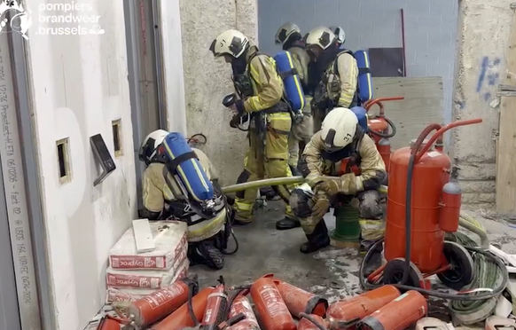 Brand in Brüssel: Feuerwehrleute versuchen, in den feststeckenden Aufzug zu kommen.