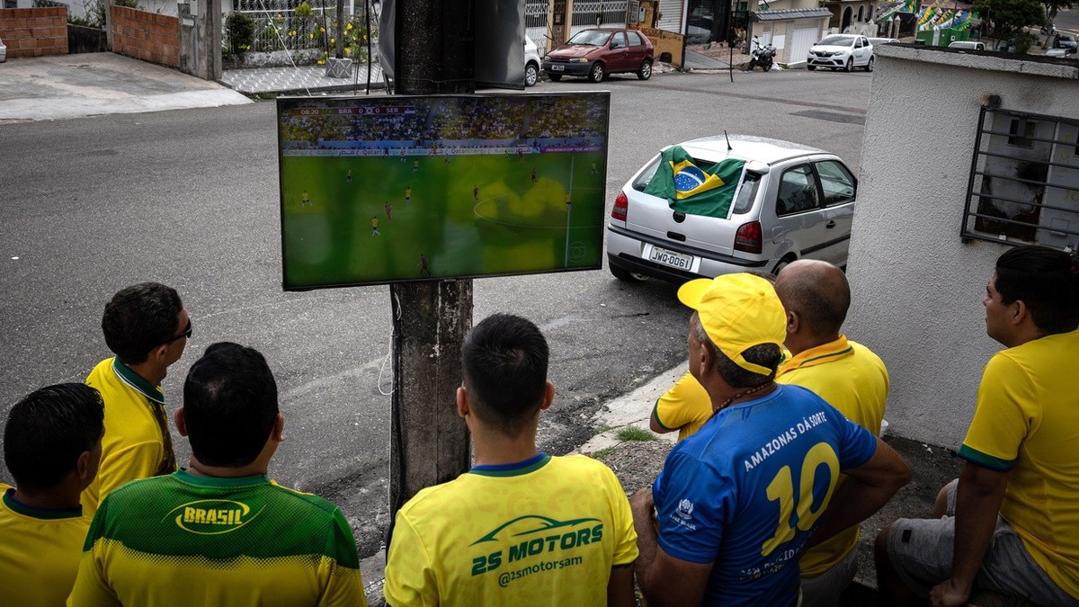 epa10326492 Fans watch Brazil's World Cup match against Serbia on a television fixed to a light pole, in Manaus, Brazil, 24 November 2022. Brazil won the match 2-0. EPA/Raphael Alves