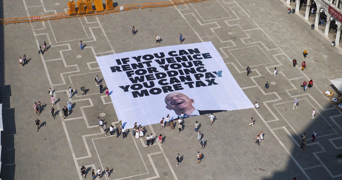 epa12192418 A handout photo made available by Greenpeace press office shows activists of the environmental group Greenpeace unfolding a giant banner with the image of US businessman and Amazon founder ...