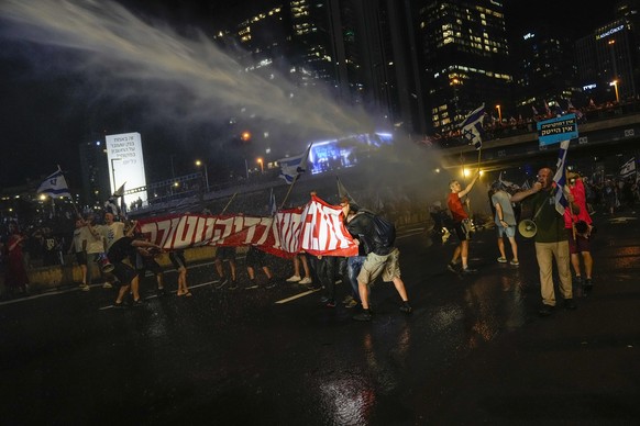 Israeli police use a water cannon to disperse demonstrators blocking a freeway during a protest against plans by Prime Minister Benjamin Netanyahu&#039;s government to overhaul the judicial system in  ...