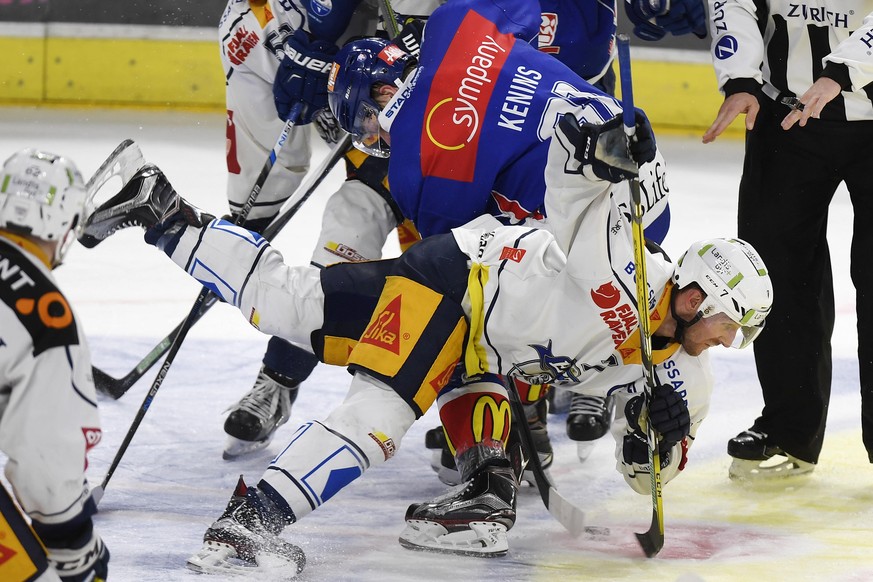 Der Zuercher Ronalds Kenins, links, drueckt den Zuger David McIntyre, rechts, aufs Eis, waehrend dem Eishockey-Qualifikationsspiel der National League A zwischen den ZSC Lions und dem EV Zug, am Freit ...