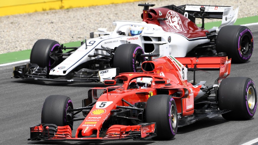 Ferrari driver Sebastian Vettel of Germany, front, and Sauber driver Marcus Ericsson of Sweden steer their cars during the qualifying session at the Hockenheimring racetrack in Hockenheim, Germany, Sa ...