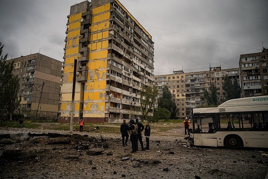Investigators examine a crater, following a missile strike in Dnipro on October 10, 2022, amid Russia's invasion of Ukraine. - The head of the Ukrainian military said that Russian forces launched ...