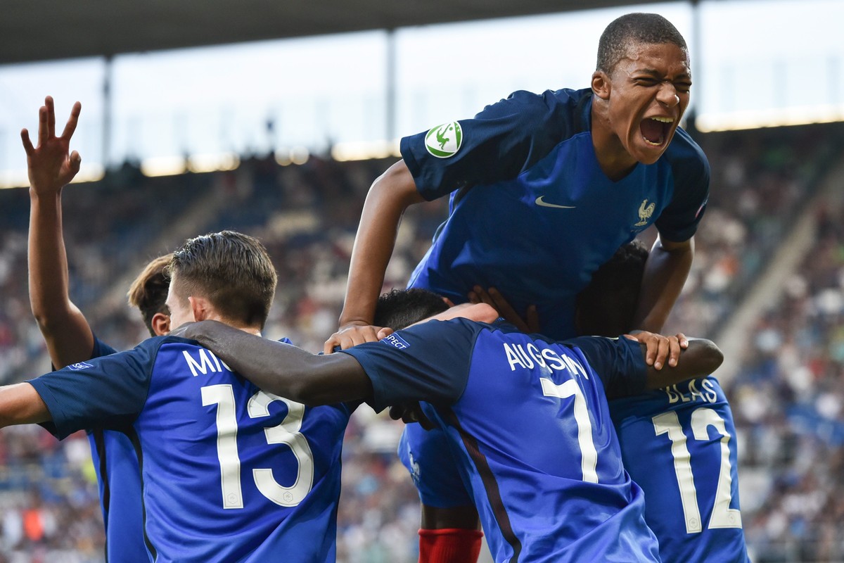 epa05439506 France's Kylian Mbappe (top) celebrates with teammates the 2-0 of Ludovic Blas during the final of the UEFA U19 European Championship between France and Italy in Sinsheim, Germany, 24 ...