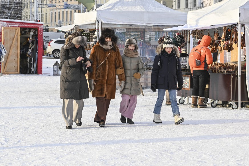 epa11053466 Tourists walk during cold weather in Helsinki, Finland, 02 January 2024. Exceptionally cold weather has been predicted for Finland with temperatures of -25 to -35 Celsius degrees. EPA/KIMM ...