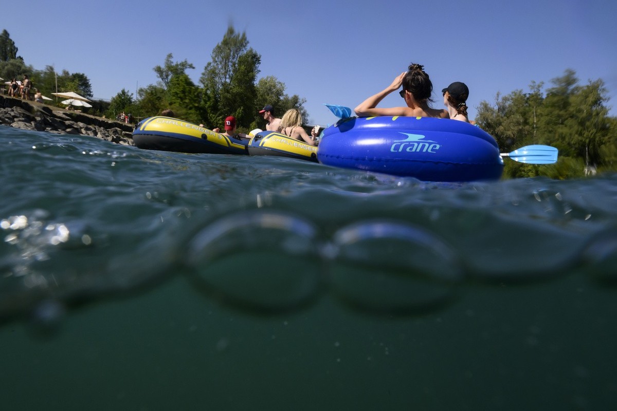 People on gummy boats on the Aare River during the sunny and warm weather, in Bern. Switzerland, Tuesday, July 19, 2022. (KEYSTONE/Anthony Anex)