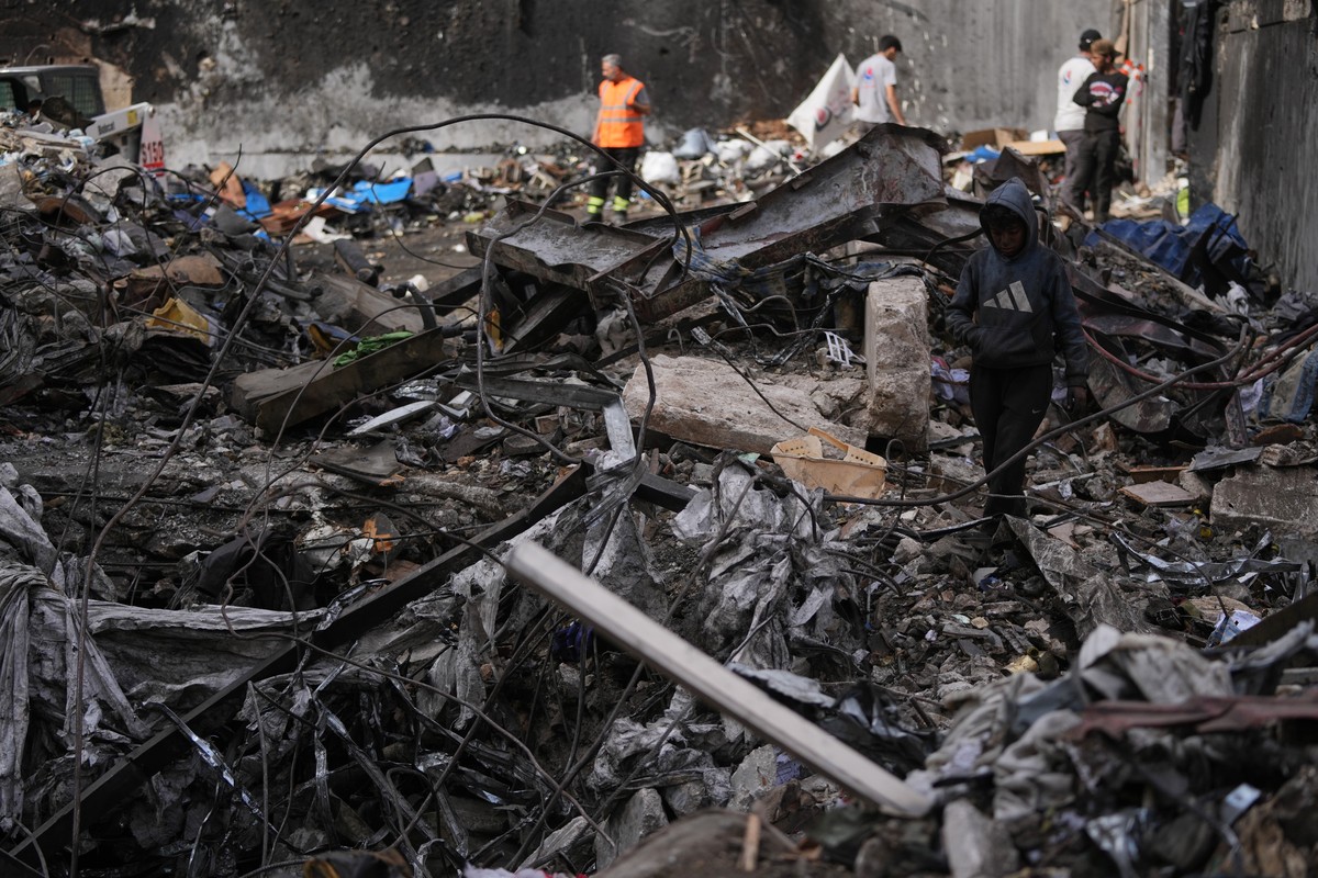 A boy walks through debris as others work in the background at the site of a building destroyed in an Israeli airstrike last Wednesday in central Beirut, Lebanon, Tuesday, April 14, 2026. (AP Photo/Ha ...