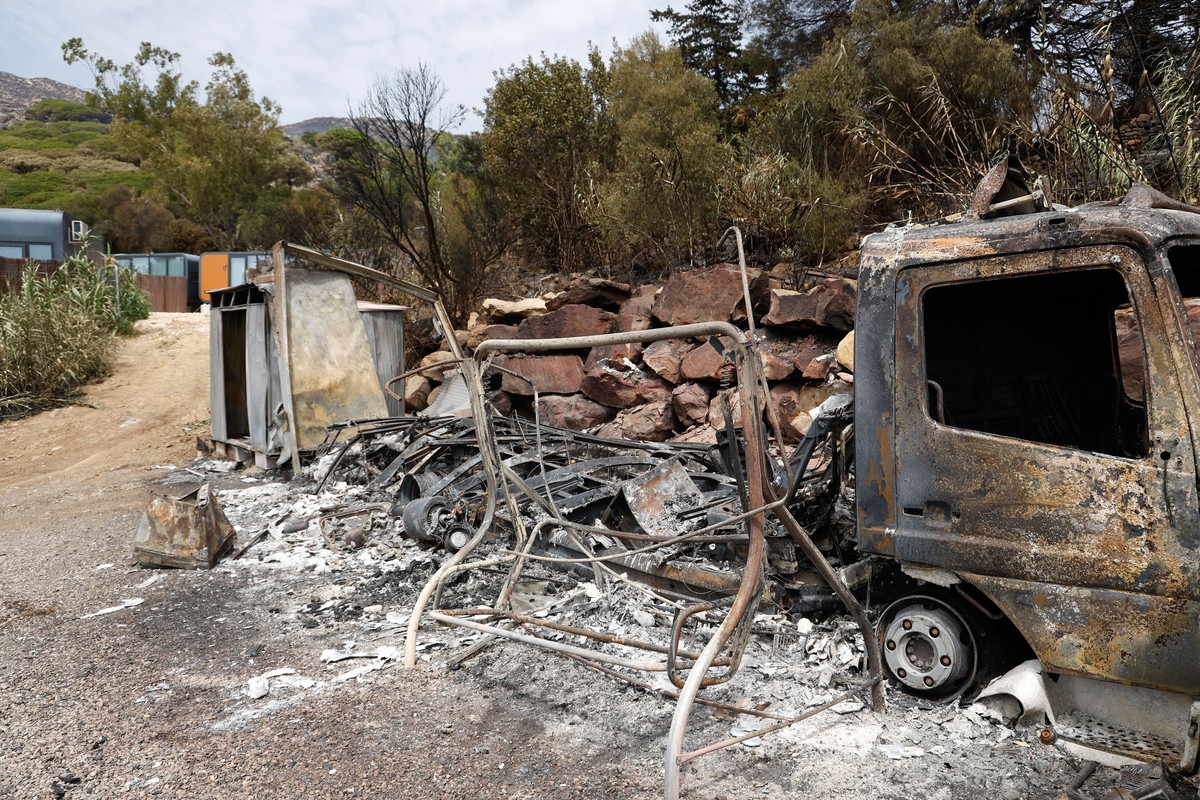 epa12286967 A charred vehicle at a camping area affected by a wildfire in Tarifa, Andalusia, southern Spain, 06 August 2025. In the Spanish region of Andalusia, several hotels and tourist facilities h ...