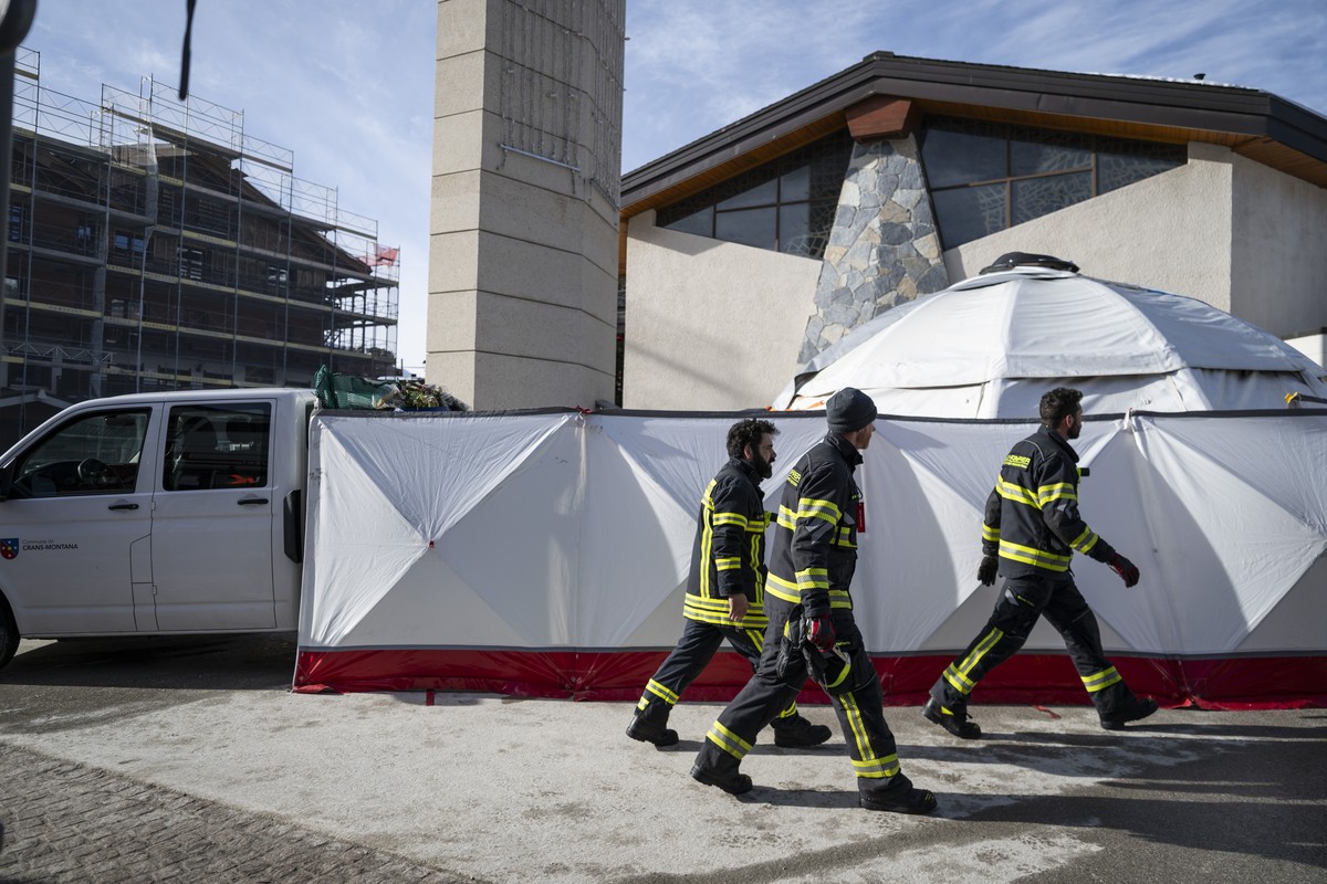Firemen clean up the memorial for the victims of the deadly fire at the "Le Constellation" bar, after the memorial caught fire in Crans-Montana Switzerland, early on Sunday, February 1, 2026 ...