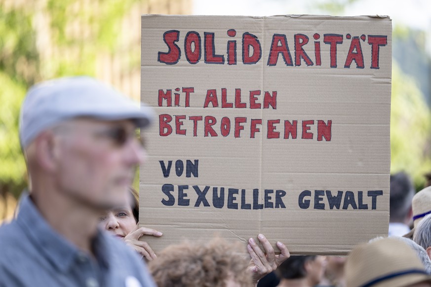 Teilnehmende bei einer Mahnwache gegen sexualisierte Gewalt halten Plakate hoch, am Montag, 27. Juli 2026 in Untersiggenthal. (KEYSTONE/Andreas Becker)