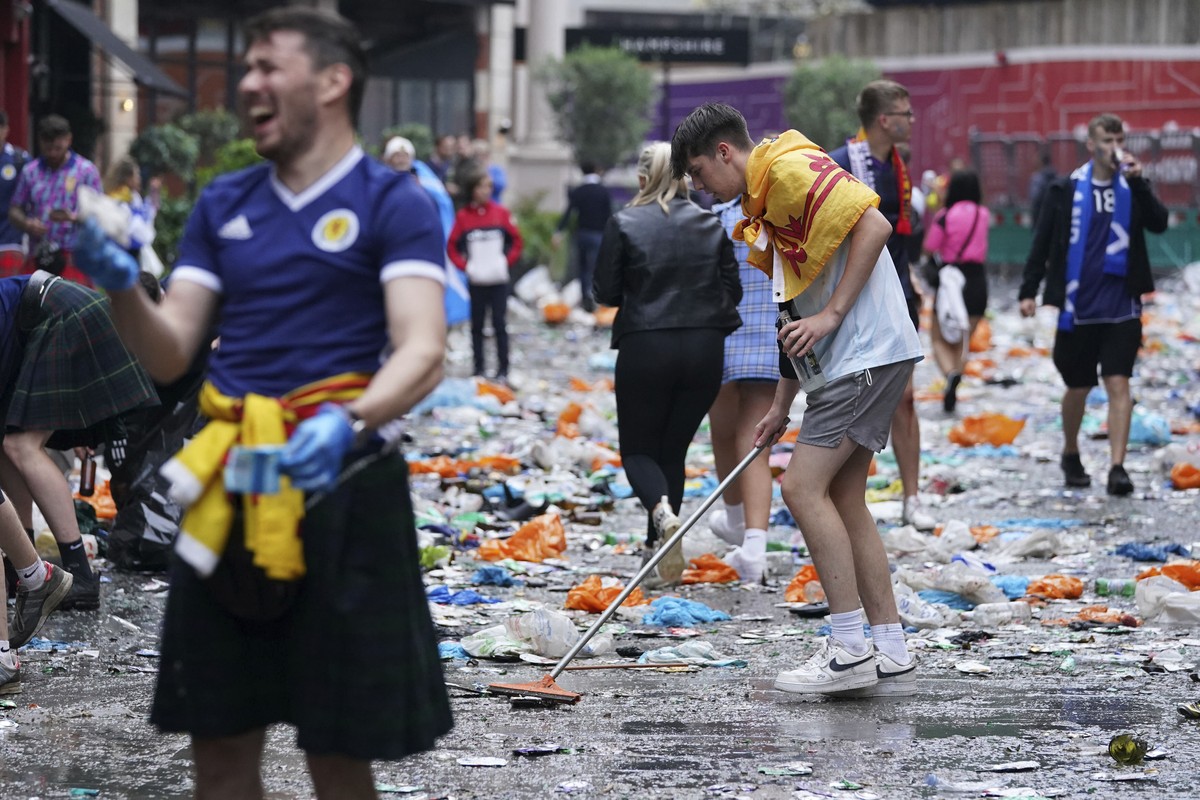 Scotland fans helps clean up litter, after fans gathered in Leicester Square prior to the Euro 2020 soccer championship group D match between England and Scotland, in London, Friday, June 18, 2021. (K ...