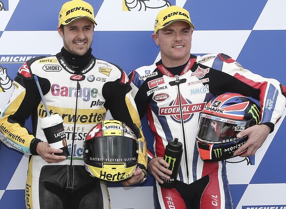 Moto2 riders Thomas Luthi of Switzerland, center, poses with Mattia Pasini of Italy, left, and Sam Lowes of Britain for a photo after taking pole position for the Australian Motorcycle Grand Prix at P ...