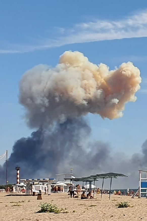 Rising smoke can be seen from the beach at Saky after explosions were heard from the direction of a Russian military airbase near Novofedorivka, Crimea, Tuesday Aug. 9, 2022. The explosion of munition ...