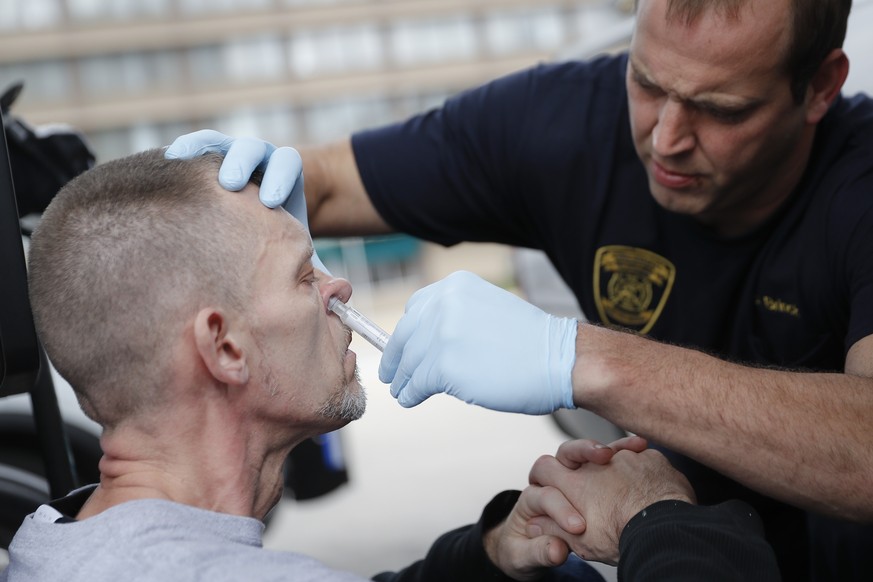 FILE - In this Nov. 2, 2017, file photo, a medic with the Cincinnati Fire Department nasally administers Naloxone to a man while responding to a possible overdose report at a gas station in downtown C ...