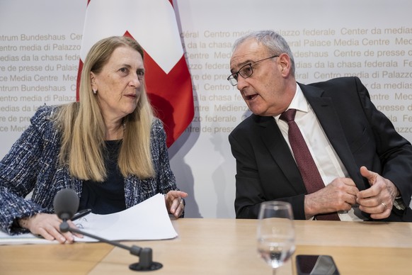 Swiss Federal Councillor Guy Parmelin, right, and Helene Budliger Artieda, State secretary for economy, talk after informing during a press conference on the new import tariffs into the US, Friday, No ...