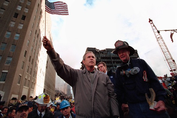 IMAGO / ZUMA Wire

20 Jahre Anschläge vom 11. September: World Trade Center Sept. 14, 2001 - New York City, NY, USA - US President George W. Bush waves an American flag standing atop rubble from the d ...