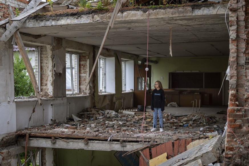 Anna Skiban, 12, stands in the rubble of her former classroom, in the same position where her desk sat before the Mykhailo-Kotsyubynske&#039;s lyceum was bombed by Russian forces on March 4, in Cherni ...