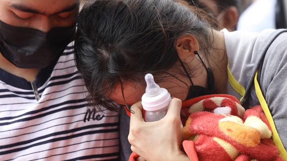 epa10228491 Relatives of the deceased mourn, at a crime scene after a mass shooting by a former policeman at a children care center in Nong Bua Lamphu province, northeastern Thailand, 07 October 2022. ...