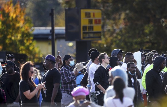 Dozens of onlookers gathered at the scene where rapper Young Dolph was killed at a cookie shop in Memphis, Tenn., Wednesday, Nov. 17, 2021. Young Dolph, widely admired in the hip-hop community for his ...