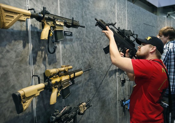 FILE--In this Jan. 19, 2016 file photo, Nolan Hammer looks at a gun at the Heckler &amp; Koch booth at the Shooting, Hunting and Outdoor Trade Show in Las Vegas. The largest gun industry trade show wi ...