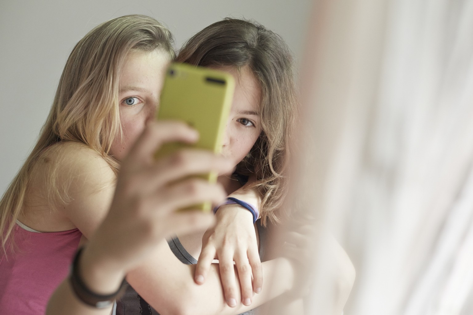 Die beiden Mädchen suchen gerade nach dem idealen Aufnahmewinkel für ein Selfie. Smartphones können manchmal ganz schön stressen.