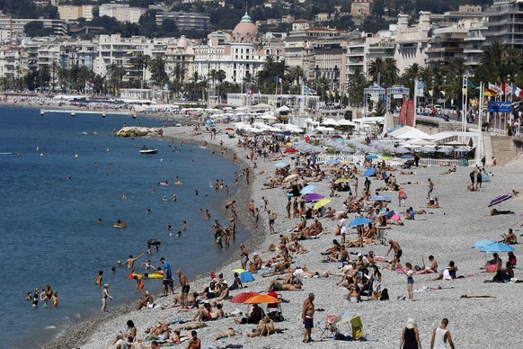 epa08536601 People enjoy the sun and the sea on a beach in Nice, southern France, 09 July 2020. Temperatures reached up to 30 degrees Celsius in Nice.  EPA/SEBASTIEN NOGIER