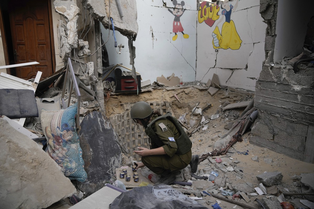 An Israeli soldier lights candles at the entrance of a tunnel where the military says six Israeli hostages were recently killed by Hamas militants in the southern Gaza Strip on Friday, Sept. 13, 2024. ...